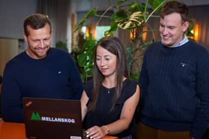 Glada medarbetare framför en dator